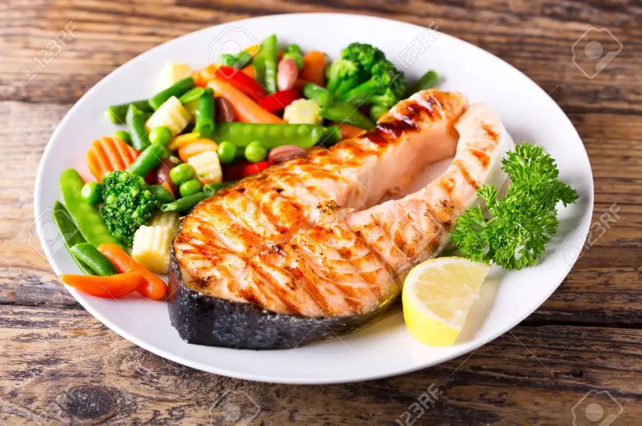 Salmón cocinado con verduras, como ejemplo de una comida.