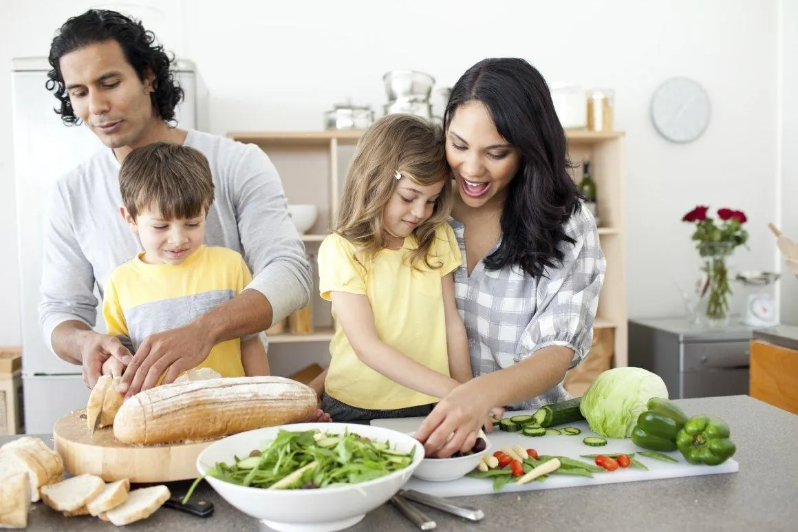 Una familia prepara verduras en la cocina.